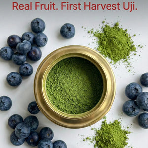 Gold container of green powder with blueberries and more green powder on a white background, featuring 'Real Fruit. First Harvest Uji.